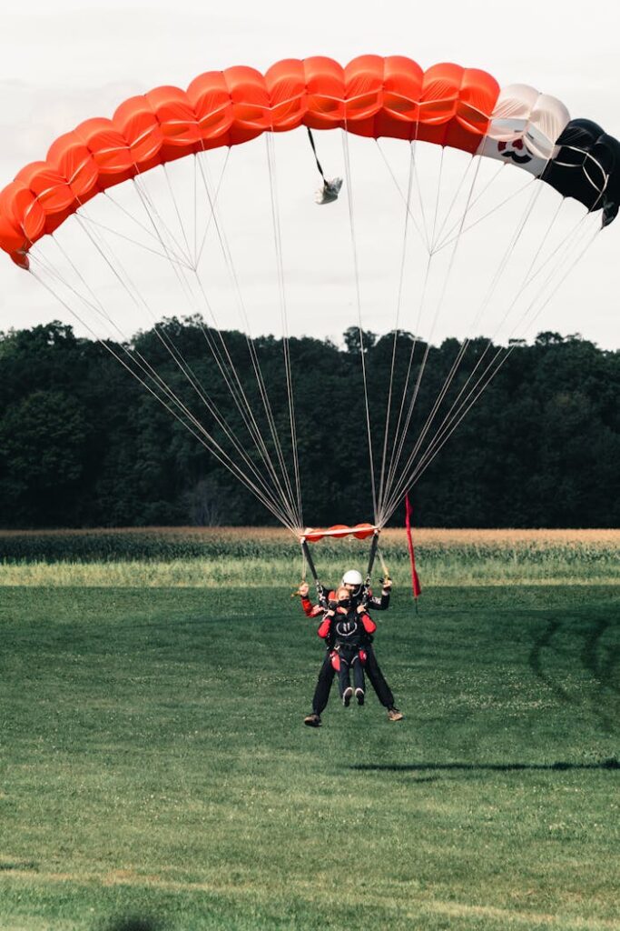 Tandem skydivers land safely in a green field near Quebec City, Canada.